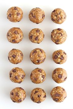 twelve chocolate chip oatmeal cookies arranged in rows on a white surface, ready to be eaten