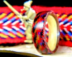 a wooden ring sitting on top of a table next to a figurine and rope