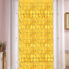 a living room filled with furniture and a yellow wall hanging on the side of a window