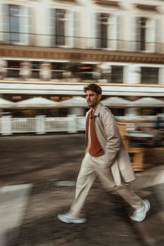 a man in a suit and tie walking down the street