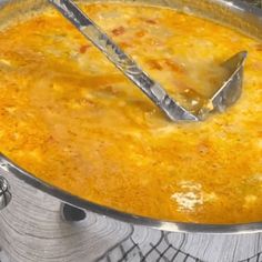 a large pot filled with lots of food on top of a stove next to a spatula