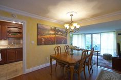 a dinning room table with chairs and a painting on the wall