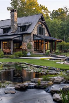 a house with a pond in front of it and lots of rocks on the ground