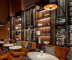 the wine cellar is filled with many bottles and glasses on shelves that are lined up against the wall