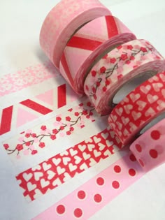 two rolls of washi tape with hearts and flowers on them, sitting next to each other