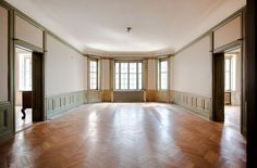 an empty room with wooden floors and windows