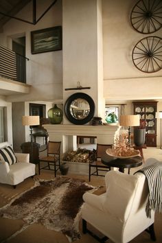 a living room filled with furniture and a fire place in the middle of an open floor plan