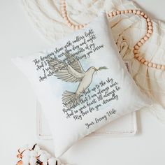 a white pillow with a poem on it next to some beads and a beaded necklace