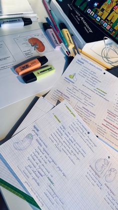 several notebooks and pens are sitting on a desk