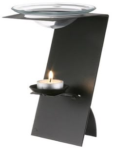 a lit candle is on top of a black stand with a glass plate in the middle