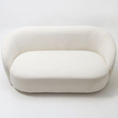 a white couch sitting on top of a white floor