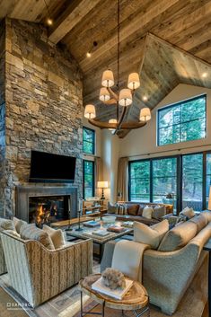 a living room filled with lots of furniture and a fire place in front of a large window