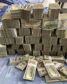 stacks of money sitting on top of a bed