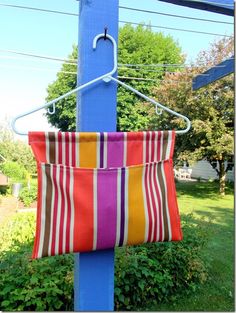 a colorful striped bag hanging from a blue pole