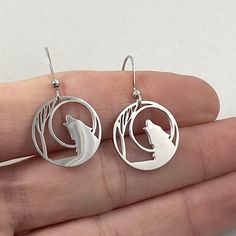 "Lone Wolf circle outline earrings, Stainless steel non tarnish. The lone wolf represents the power knowledge, balance, endurance, we gain with mindful solitude. We all need those moments. Fish Hook style earwire of Stainless Steel Charm measures just over 3/4\" wide (18mm) Stainless steel / non-tarnish / no plating See Care and Wear Instructions on home page for more information on Stainless Steel jewelry Matching Pendants in two sizes also available ⓒ All Designs and Images are copyrighted by Wolf Earrings, Matching Pendants, The Lone Wolf, Jewelry Matching, Hogwarts Dr, Circle Outline, Locket Bracelet, Glass Locket, Interesting Ideas