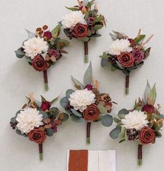 wedding bouquets with flowers and foliage arranged on the wall next to an open book