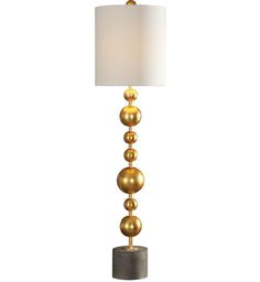 a lamp with three balls on the base and a white linen shade is placed next to it