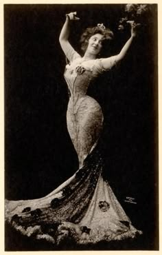 an old fashion photo of a woman in a long dress with flowers on her head