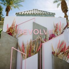 a sign that says revolf on the side of a building with palm trees in the background