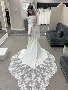 a woman in a wedding dress looking down at the floor with her veil pulled back