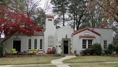 a white house with red roof and windows