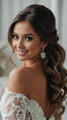 a woman with long hair wearing a wedding dress and earrings on her head, smiling at the camera