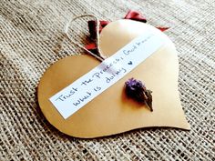 a heart shaped paper with a flower on it and a note attached to the side