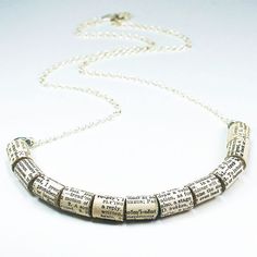 a book page necklace is shown on a white surface