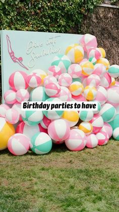 a bunch of balloons that are on the ground in front of a sign with words birthday parties to have