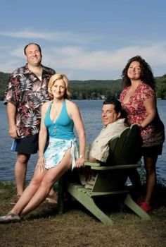 three people standing next to each other near the water