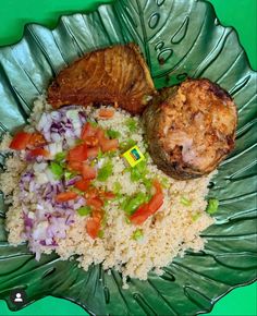 a green plate topped with rice and meat next to veggies on top of it