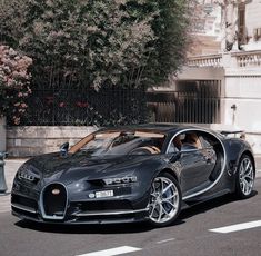 the bugatti is parked on the side of the road in front of a building