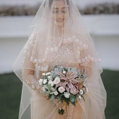 a woman wearing a veil and holding a bouquet