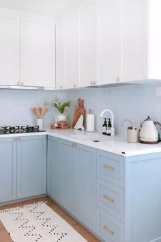 a kitchen with blue cabinets and white counter tops