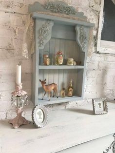 an old white painted dresser with candles and figurines