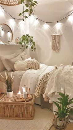 a white bedroom with plants and wicker baskets on the floor, lights strung from the ceiling