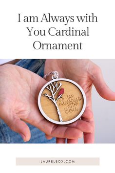 a person holding a wooden ornament with the words i am always with you