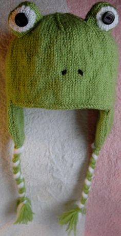 a knitted frog hat with eyes on it's head and ears sticking out