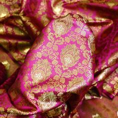 Magenta Wedding Dress Fabric Brocade by the Yard Indian Brocade Jacquard Banarsi Saree Crafting Sewing Costume Pillow Cover Home Décor Skirt. Tanchoi Banarsi Brocade Fabric. This is a beautiful brocade floral design fabric in colors Red, Pink and gold. ➤ Fabric Type: Blended Silk (Viscose & Silk Satin) ➤ Color: Magenta, Pink, Green and Gold ➤ Code: bg2482 ➤ Width of the fabric is 43 inches. ➤ Listing for 1 Yard of fabric.  ➤ Care: Dry Clean Only You can use this fabric to make Dresses, Tops, Blouses, Jackets, Crafting, Clutches or Evening Bags, embellish your clothes, Pillows, Drapery, Home Décor, Outdoor, Quilting, Sewing, General, Upholstery etc. use it for scrap booking projects. Tanchoi is one of the weaving techniques involving a single or double warp and two to five colors on the wef Magenta Wedding Dress, Magenta Wedding, Bridal Anklet, Jacquard Saree, Banarasi Brocade, Wedding Dress Fabric, Banarsi Saree, Color Magenta, Wedding Dress Fabrics