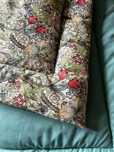 an upholstered seat cushion on top of a blue couch with floral designs and leaves