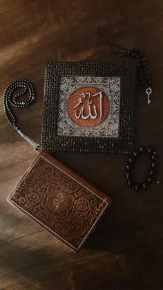 a wooden table topped with an ornately decorated box next to a rosary and key