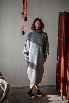 Keep yourself cozy and warm during those cold autumn and winter months in this versatile, soft Merino wool sweater dress designed to last you years. The oversized fit comes with a calf-length hem, which is ribbed like the sleeve ends and the turtleneck. The roll neck is so chunky that it can easily replace the scarf in a windy day. The long ribbed cuffs make the dress stand out and give grace to your hands, whereas the raglan sleeves give enough room for the shoulders. This is a timeless wool dr Wool Long Dress, Long Wool Dress Outfit, Styling Dresses In Winter, Wool Dress Winter, Grey Dress Outfit, Long Jumper Dress, Knitted Dress Outfit, Wool Dresses, Cozy Knitwear