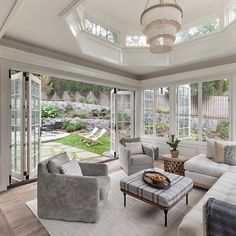 a living room filled with furniture and lots of windows