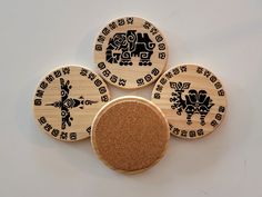 three wooden coasters with designs on them sitting next to each other in front of a white background