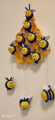 bees and honeycombs are hanging from strings on the wall in front of a christmas tree