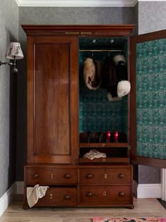 an armoire with two stuffed animals hanging on it's doors, in a living room