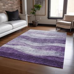 a living room filled with furniture and a purple rug on top of a hard wood floor