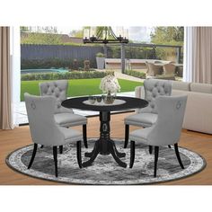 a round dining table with four chairs and a rug on the floor in front of it