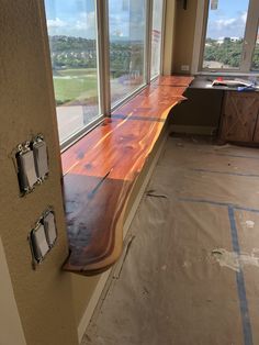 an empty room with large windows and wooden flooring on the side of the wall