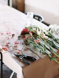 flowers and scissors are sitting on the table